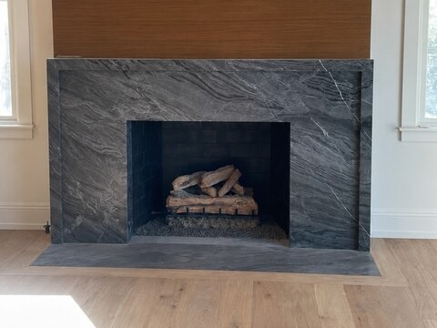 Fireplace surround fabricated from natural stone with dramatic veining